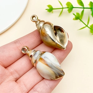 Macro detail of acrylic sea shell pendants with electroplated finish for DIY crafts