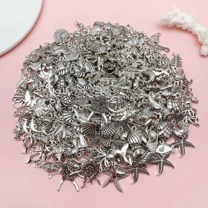 Detailed flat lay of silver antique sea animal charms including starfish and shells