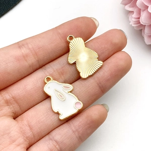 Detailed front and back view of white enamel rabbit charm with golden textured back