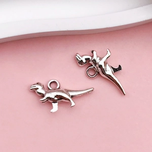 Detailopname van twee zilveren Tyrannosaurus Rex metalen bedeltjes voor DIY-sieraden
