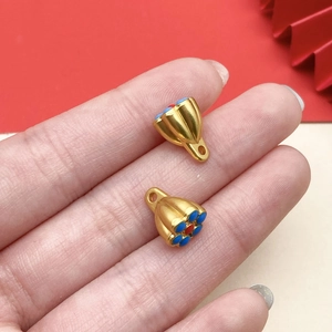 Close-up of gold enamel flower pendants for DIY jewelry making held in hand