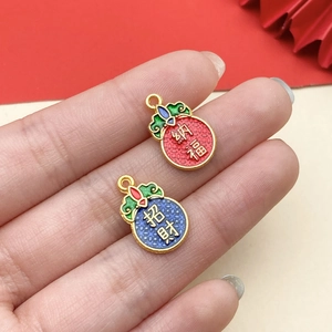 Detailed close-up of Chinese enamel charms with Na Fu and Zhao Cai lucky symbols
