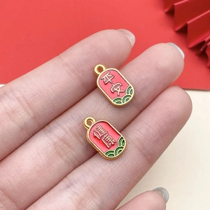 Macro shot of red enamel pendants with golden Pingan and Jiankang lettering for DIY jewelry