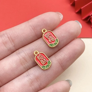 Close-up of gold-plated red enamel charms with Chinese lucky calligraphy and cloud patterns