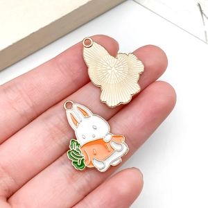 Détail de breloques lapin blanc et carotte en alliage pour création de bijoux