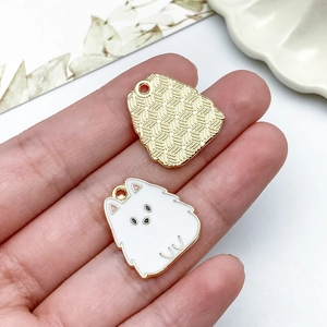 Dettagli fronte e retro di ciondoli a cucciolo in smalto bianco con finitura dorata