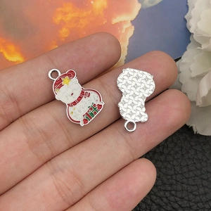 Detail of Christmas snowman enamel pendant showing front XMAS design and star texture back