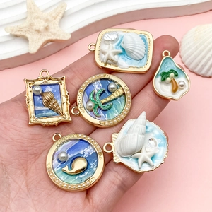 Pendentifs sur le thème de l'île avec cocotiers et étoiles de mer en alliage émaillé