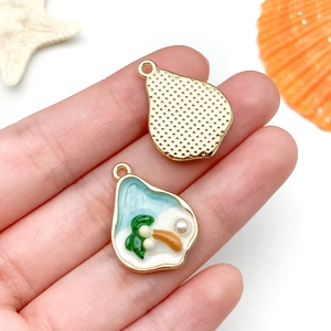 Détail du pendentif île en émail en forme de poire avec palmier et perle sur métal doré