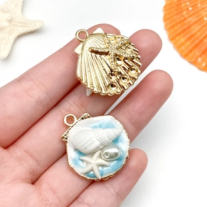 Détail macro de pendentifs tropicaux en forme de coquillage et étoile de mer avec perle