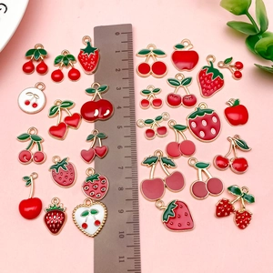 Detail of assorted fruit enamel pendants including strawberry and cherry for DIY jewelry