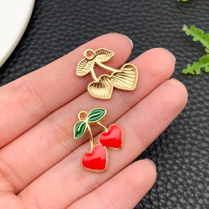 Detailed close-up of cherry alloy charms for DIY jewelry making on leather surface