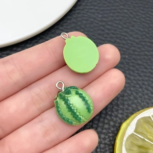 Détail macro d'un mini pendentif pastèque en résine avec des motifs texturés verts réalistes