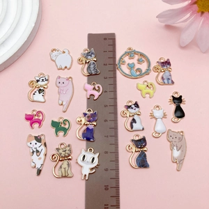 Size comparison of assorted colorful enamel cat charms for DIY jewelry making