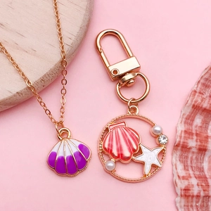Meeres-Halskette und Schlüsselanhänger Set mit Perlmuttmuscheln auf rosa Grund