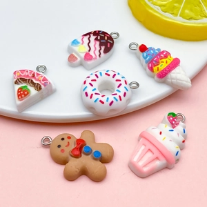 Macro shot of assorted resin dessert charms like donuts and gingerbread men with metal loops