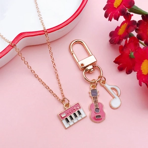 Dettaglio portachiavi chitarra rosa e collana pianoforte in un vassoio ceramica a cuore