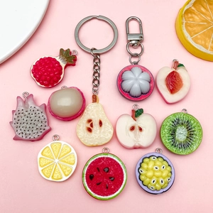 Flat lay of colorful resin fruit charms including kiwi and lemon with metal keychains