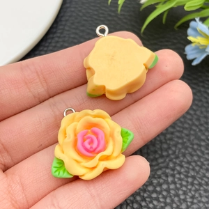 Macro view of resin camellia pendant with yellow petals and metal loop for DIY crafts