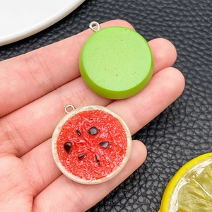 Detail of realistic resin watermelon pendants with silver loops for DIY jewelry making