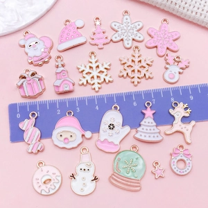 Set di ciondoli natalizi rosa e bianchi con Babbo Natale e fiocchi su sfondo rosa tenue