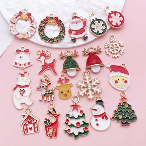 Détail de breloques de Noël en émail assorties avec rennes, arbres et cloches pour DIY