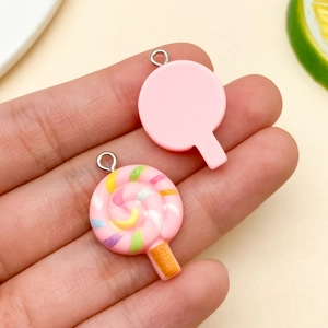Macro detail of a 3D resin lollipop charm with pink swirl design for DIY jewelry