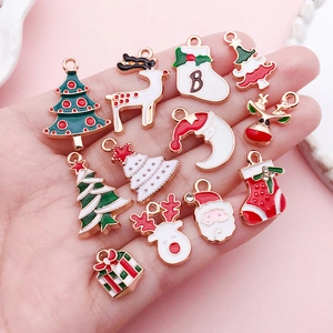 Handheld display of enamel Christmas pendants including reindeer and tree for DIY jewelry