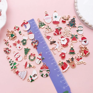 Macro detail of assorted Christmas enamel charms including Santa, reindeer, and snowflakes
