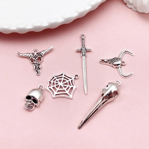 Detailed view of silver gothic alloy pendants featuring skull and spider motifs