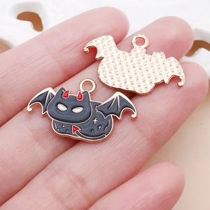 Macro view of bat-shaped alloy pendant with red horns and black drip oil finish