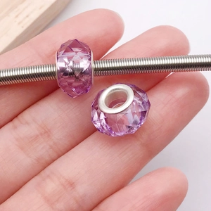 Detalle de cuenta facetada de resina morada con núcleo de plata en una pulsera DIY
