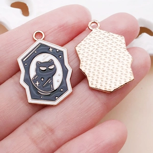 Detailed view of cat silhouette enamel charms with moon and stars in hand