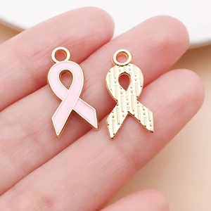 Dettaglio di ciondoli a nastro in smalto rosa e oro per gioielli di sensibilizzazione