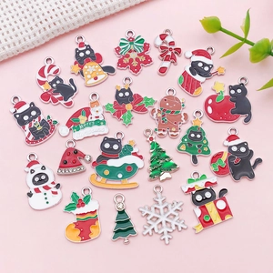 Detalle de colgantes navideños de esmalte con gatos negros para creación de joyería DIY