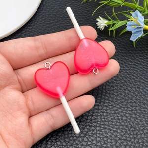 Dettaglio di ciondoli a lecca-lecca a cuore rosa con glitter per la creazione di gioielli