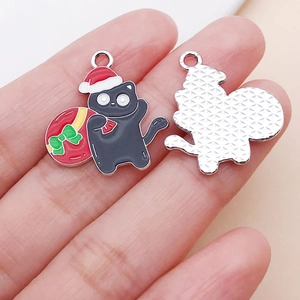 Detalle de colgante de gato negro navideño esmaltado con textura frontal y trasera