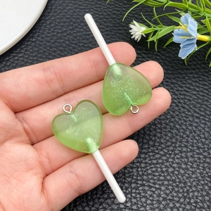 Vista dettagliata dei ciondoli lecca-lecca a forma di cuore in resina verde per bigiotteria
