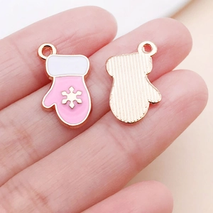 Detailed view of pink Christmas glove charm with gold snowflake and enamel coating