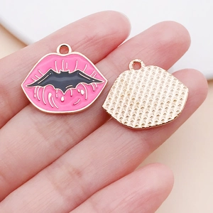 Detail of pink lip-shaped alloy pendant with black bat motif and gold textured backing