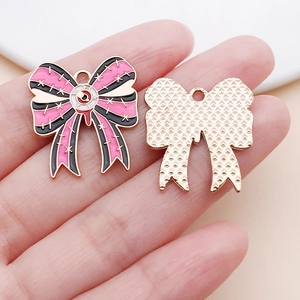 Detailed view of pink ghost bow alloy pendant with enamel finish and gold textured back