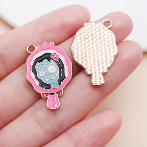 Macro detail of enamel rose pink hand mirror pendants with blue zombie girl design