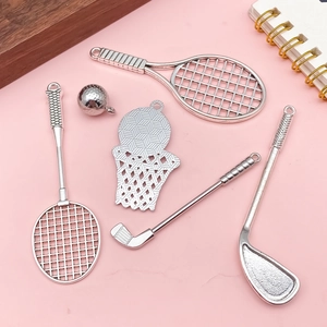 Set di ciondoli sportivi in miniatura con racchette da tennis e badminton su sfondo rosa