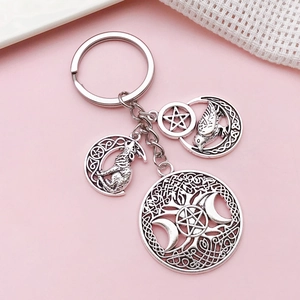 Porte-clés arbre de vie argenté vintage et pendentif loup sur fond rose doux