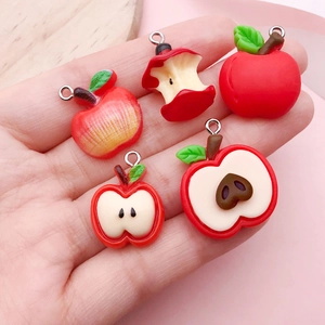 Mini ciondoli a mela in resina in 5 stili tenuti in mano per mostrare taglia DIY