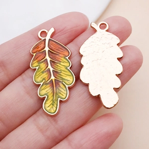 Detailaufnahme der Ahornblatt-Anhänger mit orangefarbenem Emaille und Roségold-Rückseite