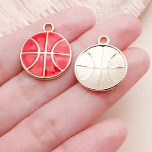 Detail eines roten Emaille-Basketball-Anhängers mit goldener Rückseite und Radialstruktur