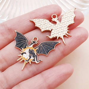 Detailed view of dragon charms showing colorful enamel front and textured gold metal back