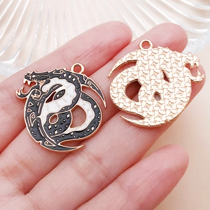 Macro detail of gothic dragon moon pendant with black enamel finish and gold backing