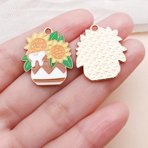 Détail de pendentifs en émail chat et tournesol montrant les finitions avant et arrière